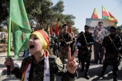 FILE - Fighters of the Syrian Democratic Forces (SDF) march during a rally in al-Qahtaniyah, Syria, Oct. 7, 2019.
