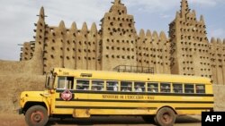 Un bus du ministère de l'Education passe devant la Grande Mosquée de Djenné dans la région du Delta du Niger au centre du Mali, 9 février 2005.