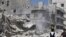 Civilians and members of the Free Syrian Army inspect a damaged building in al-Kalaseh neighbourhood in Aleppo, after a morning jet air strike, September 19, 2012. 