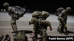 Des parachutistes britanniques la nuit à l'aéroport militaire de Grier Labouihi, dans le sud-est du Maroc, le 9 juin 2021, lors de l'exercice militaire "African Lion".