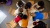 FILE- Children play with a therapist in the pediatric unit of the Robert Debre hospital, in Paris, France, March 2, 2021. 