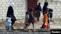 Cư dân từ thị trấn Ras al-Ain ở miền bắc Syria vượt biên giới vào Thổ Nhĩ Kỳ, ngày 13/11/2012.