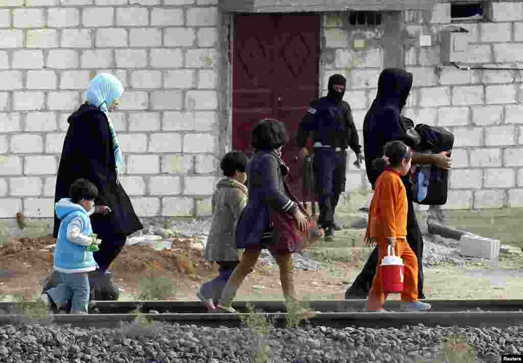 People from the northern Syrian town Ras al-Ain attempt to cross into Turkey, as seen from the Turkish border town of Ceylanpinar, Sanliurfa province, November 13, 2012.