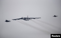 FILE - A U.S. Air Force B-52 (C) flies over Osan Air Base in Pyeongtaek, South Korea, Jan. 10, 2016.