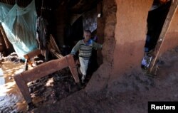 A child walks in his house, which was partly destroyed by flooding water after a dam burst, in Solio town near Nakuru, Kenya May 10, 2018.