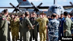 Para pejabat dan awak pencarian udara pesawat Malaysia Airlines yang hilang di markas angkaan udara Australia dekat Perth (29/4). (Reuters/Richard Polden)