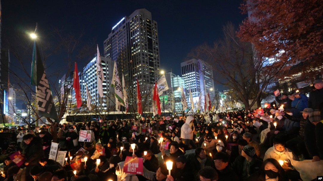People hold candles during a candlelight vigil against South Korean President Yoon Suk Yeol in Seoul, South Korea, Dec. 4, 2024. 