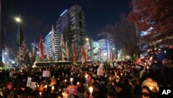 People hold candles during a candlelight vigil against South Korean President Yoon Suk Yeol in Seoul, South Korea, Dec. 4, 2024. 