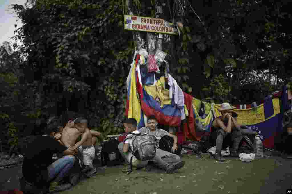 Los migrantes descansan en el punto que marca la frontera entre Panamá y Colombia durante su viaje a través del Tapón del Darién para llegar a EEUU, el martes 9 de mayo de 2023. [Foto: Iván Valencia]