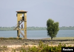 FILE - A member of Border Guard Bangladesh (BGB) stands guard on a watchtower near the Bangladesh-Myanmar border to try to prevent Rohingya refugees from illegal border crossing, in Teknaf near Cox’s Bazar, Bangladesh, Nov. 22, 2016.