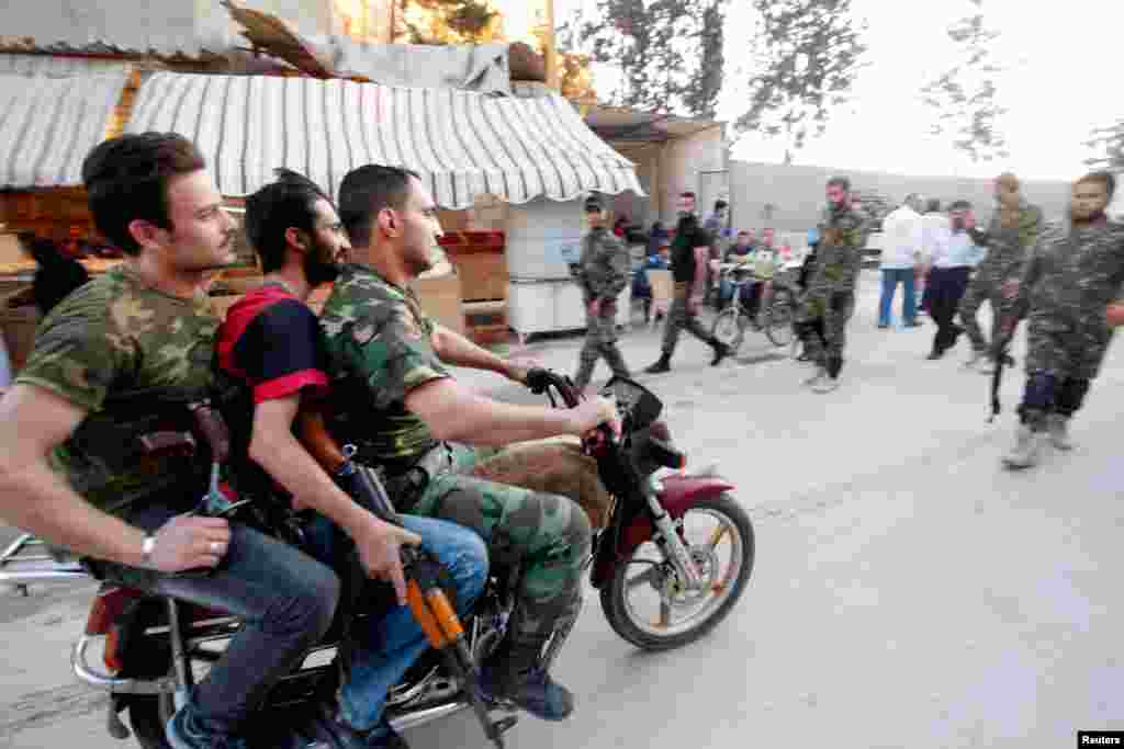 Naoružani &scaron;iitski borci prolaze kroz četvrt Sajeda Zainab u Damasku. 