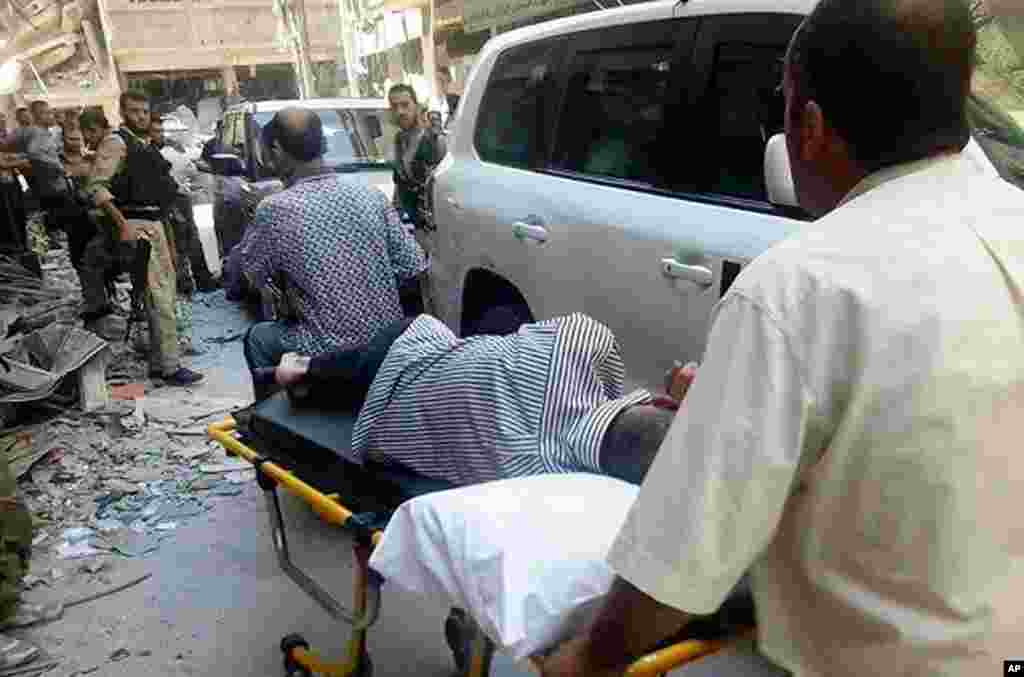 Dân Syria khiêng một người đàn ông bị thương vì vũ khí hóa học đến gặp các nhà điều tra LHQ tại vùng ngoại ô Damascus, ngày 28/8/2013.