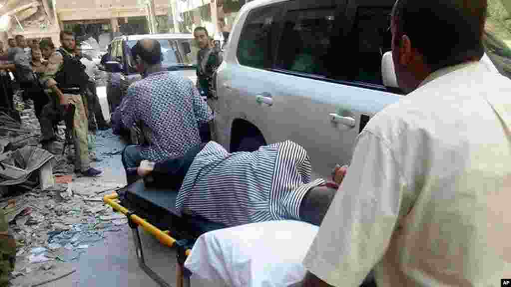 This citizen journalism image provided by the United media office of Arbeen shows Syrians moving a man who was allegedly exposed to chemical weapons to show him to U.N. investigators in a Damascus suburb, August 28, 2013.