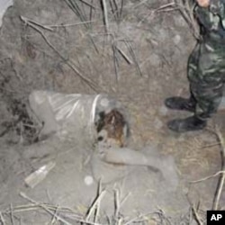 A Thai soldier stands by the body of a villager killed in the militarized border area, near a 11th-century Preah Vihear temple, between Thailand and Cambodia, February 4, 2011. Thai and Cambodian soldiers exchanged fire in a two-hour border clash on Frida