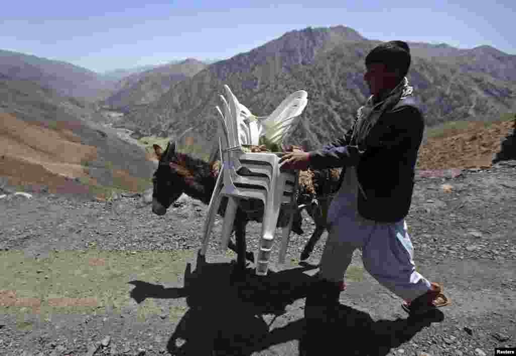 A man walks with a donkey loaded with ballot boxes and other election material to be transported to polling stations not accessible by road in Shutul, Panjshir province, June 13, 2014.
