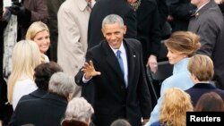 Le président Barack Obama salue la foule devant la famille Trump au Capitole, le 20 janvier 2017.