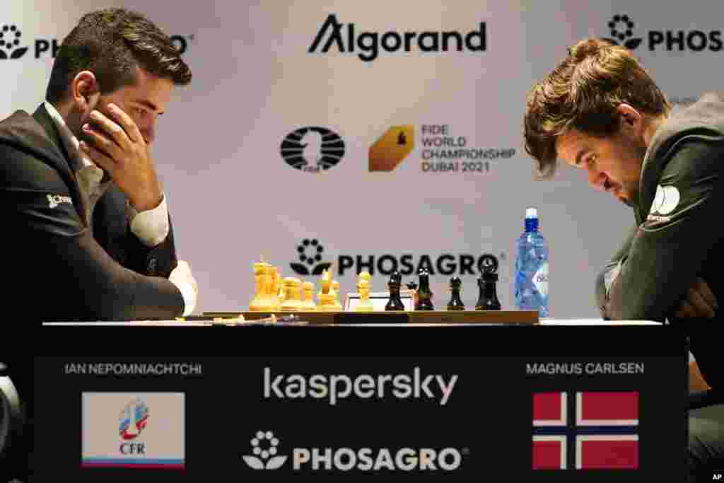 Ian Nepomniachtchi of Russia, left, and Magnus Carlsen of Norway, right, compete during the FIDE World Championship at Dubai Expo 2020 in Dubai.