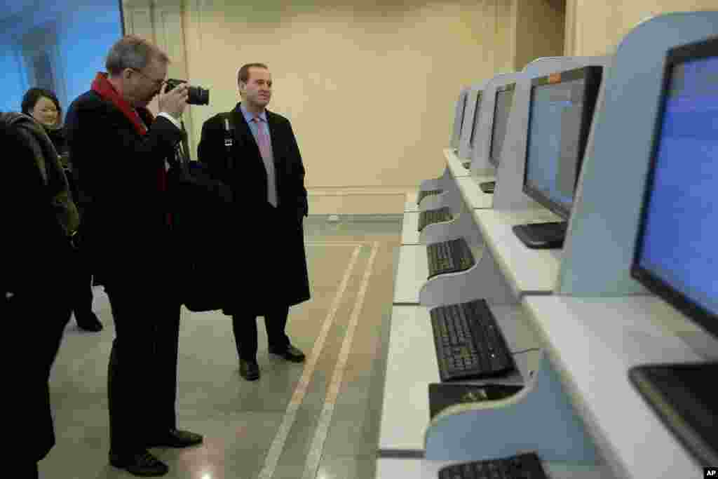 Executive Chairman of Google, Eric Schmidt, takes photographs as he tours a computer lab at Kim Il Sung University in Pyongyang, North Korea, January 8, 2013.
