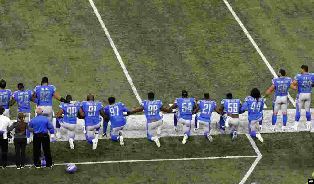 Les Lions de Detroit posent leurs genoux à terre lors de l'hymne national pour protester contre les violences faites contre les Noirs aux Etats-Unis, à Détroit, le 24 septembre 2017.