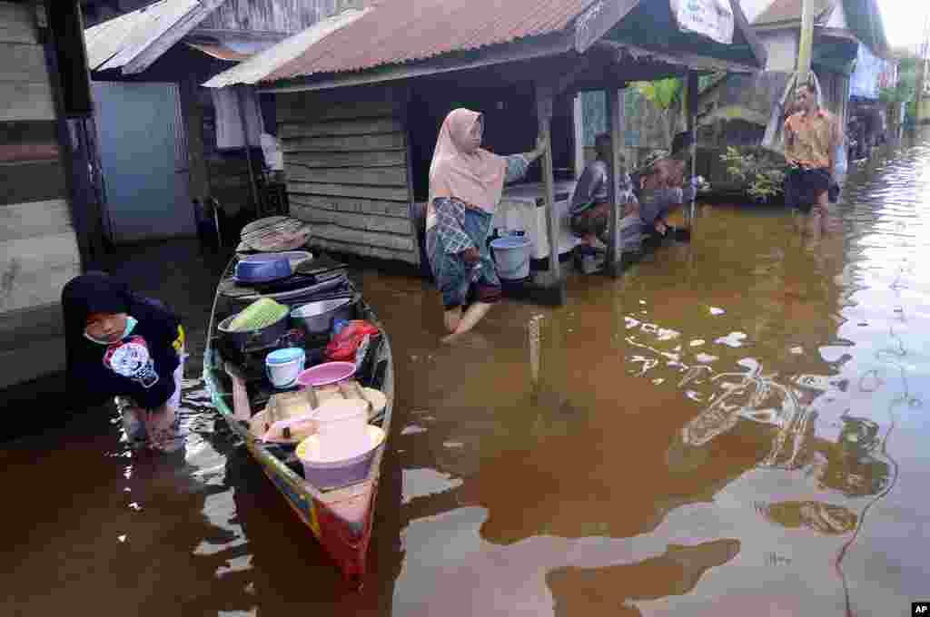 People talk outside their homes at a neighborhood affected by flood in Banjarmasin, South Kalimantan on Borneo Island, Indonesia.