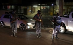 Police officers hold guns during a patrol as a nighttime curfew is reimposed amid a nationwide coronavirus disease (COVID-19) lockdown, in Pretoria, South Africa, Jan. 9, 2021.