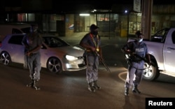 Police officers hold guns during a patrol as a nighttime curfew is reimposed amid a nationwide coronavirus disease (COVID-19) lockdown, in Pretoria, South Africa, Jan. 9, 2021.