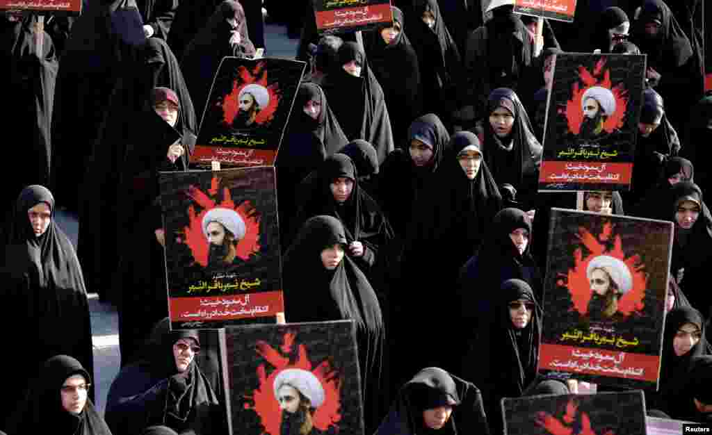 Iranian protesters hold pictures of Shi'ite cleric Sheikh Nimr al-Nimr during a demonstration condemning his execution in Saudi Arabia, at Imam Hussein Square, in Tehran, Jan. 4, 2016.