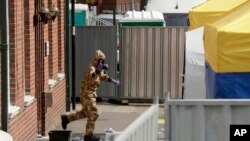 Seorang anggota tim spesialis Inggris mengenakan proteksi militer khusus saat melakukan penyelidikan kasus gas syaraf di Salisbury, Inggris, Jumat (6/7). 