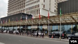 Walinzi wakiwa wamesimama mbele ya jengo la NagaWorld huku kukiwa na mgomo wa wafanyakazi huko Phnom Penh, Cambodia, Desemba 22, 2021. (Nem Sopheakpanha / VOA.