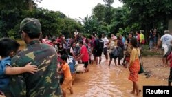 FILE - Villagers carry their belongings as they evacuate after the Xepian-Xe Nam Noy hydropower dam collapsed in Attapeu province, Laos, July 24, 2018.