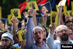 FILE - Pro-Islamist demonstrators shout slogans in favor of former Egyptian President Mohamed Morsi and hold signs that show the Rabaa hand gesture, which symbolizes support for the Muslim Brotherhood, during a rally Istanbul, Turkey, May 24, 2015.