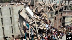 People and rescuers gather after an eight-story building housing several garment factories collapsed in Savar, near Dhaka, Bangladesh, April 24, 2013.