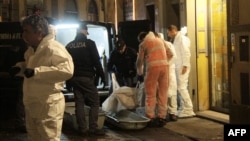 Police officers and forensics experts carry the body of Ashley Olsen, a 35-year-old American expatriate artist who was found dead in her apartment, in Florence, Italy, Jan. 9, 2016. 