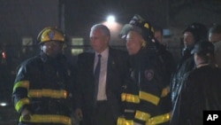 Republican presidential candidate Indiana Gov. Mike Pence talks with firefighters at New York's LaGuardia Airport after his campaign plane slid off the runway while landing, Oct. 27, 2016. 