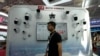 FILE - A man walks by a display of surveillance technologies for the Chinese tech company Huawei during Security China 2023 in Beijing, Wednesday, June 7, 2023. A Treasury Department rule is meant to prevent U.S. investment in certain technologies in China.