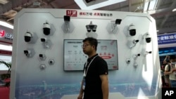 FILE - A man walks by a display of surveillance technologies for the Chinese tech company Huawei during Security China 2023 in Beijing, Wednesday, June 7, 2023. A Treasury Department rule is meant to prevent U.S. investment in certain technologies in China.