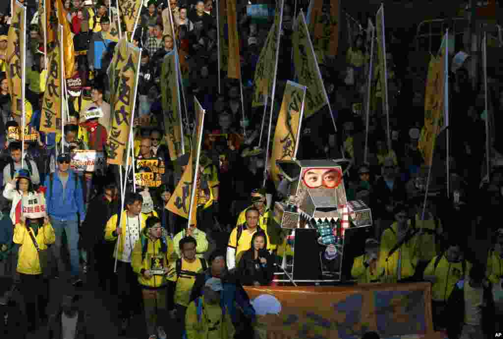 Protesters carry an effigy of a wolf representing Hong Kong&#39;s Chief Executive Leung Chun-ying march during a demonstration in Hong Kong, Jan. 1, 2014. 