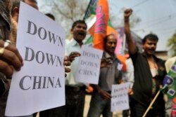 Indian activists shout slogans and hold placards during a protest in Guahati, India, Wednesday, March 21, 2012. The activists were protesting against the construction of dams in China in the middle reaches of the Brahmaputra River, or the Yarlung…