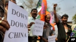 FILE - Indian activists shout slogans and hold placards during a protest in Guahati, India, in 2012. 