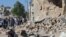 Residents look at the damage at a site hit by what activists said was a barrel bomb dropped by forces of Syria's President Bashar al-Assad, in the old city of Aleppo, May 31, 2015.