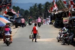 Seorang pria membawa telur saat menyeberang jalan di Pasar Sepaku di Kabupaten Penajam Paser Utara, Kalimantan Timur, 29 Agustus 2019. (Foto: Reuters)