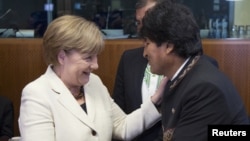 German Chancellor Angela Merkel greets Bolivian President Evo Morales at a European Union-Community of Latin American and Caribbean States summit in Brussels, June 10, 2015.