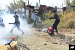 Armed Zimbabwean police battle rioters in Harare, Monday, July, 4, 2016.