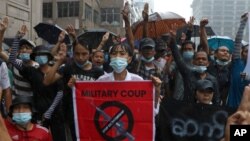 Anti-coup protesters flash the three-finger salute and chant slogan during the demonstration against the military coup in the rain at Pabedan township in Yangon, Myanmar, Friday, April 30, 2021. (AP Photo/Vincent Thian)