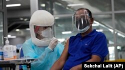 A health worker administers shots of the AstraZeneca COVID-19 vaccine at the Central Vaccination Center in Bangkok, Thailand, Thursday, July 22, 2021.