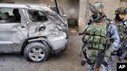 Security forces inspect the site of a car bomb attack in Baghdad's Karrada neighborhood, Iraq, Nov. 20, 2013.