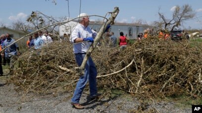 Phó TT Mike Pence tiếp tay dọn rác rưởi trong một chuyến đi thăm Rockport, Texas, một khu vực bị tác động bởi bão Harvey, Ảnh chụp ngày 31/8/2017 (AP Photo/Eric Gay)