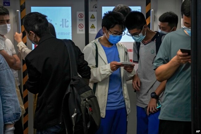 Siswa bermain game online di dalam kereta bawah tanah di Beijing, Selasa, 14 September 2021.