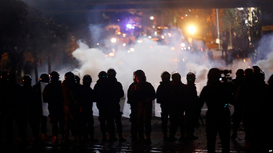 Riot police fire tear gas at supporters of the Shiite Hezbollah and Amal groups in Beirut, Dec. 17, 2019. The groups were angered by a video that showed a man insulting Shiite figures.