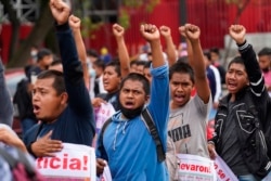 Aksi demo para pendukung dan kerabat dari 43 mahasiswa yang hilang memegang plakat dengan foto orang yang mereka cintai, dalam peringatan tujuh tahun hilangnya mereka, di Mexico City, Minggu, 26 September 2021.